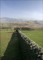 View along the top of a drystone wall towards hills