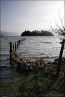 A partially submerged wire fence leading into the lake